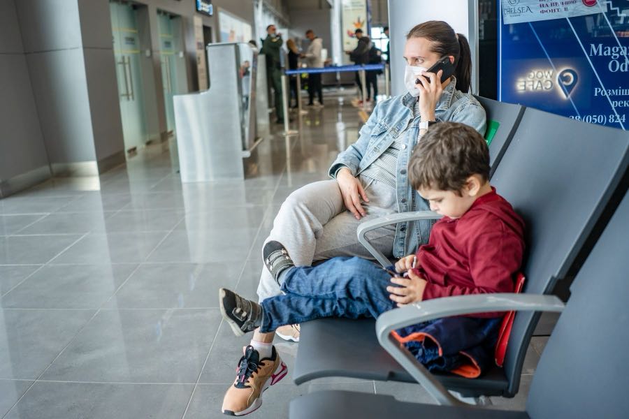Telefonuyla ilgilenen anne ve elindeki cihaza bakan çocuğu